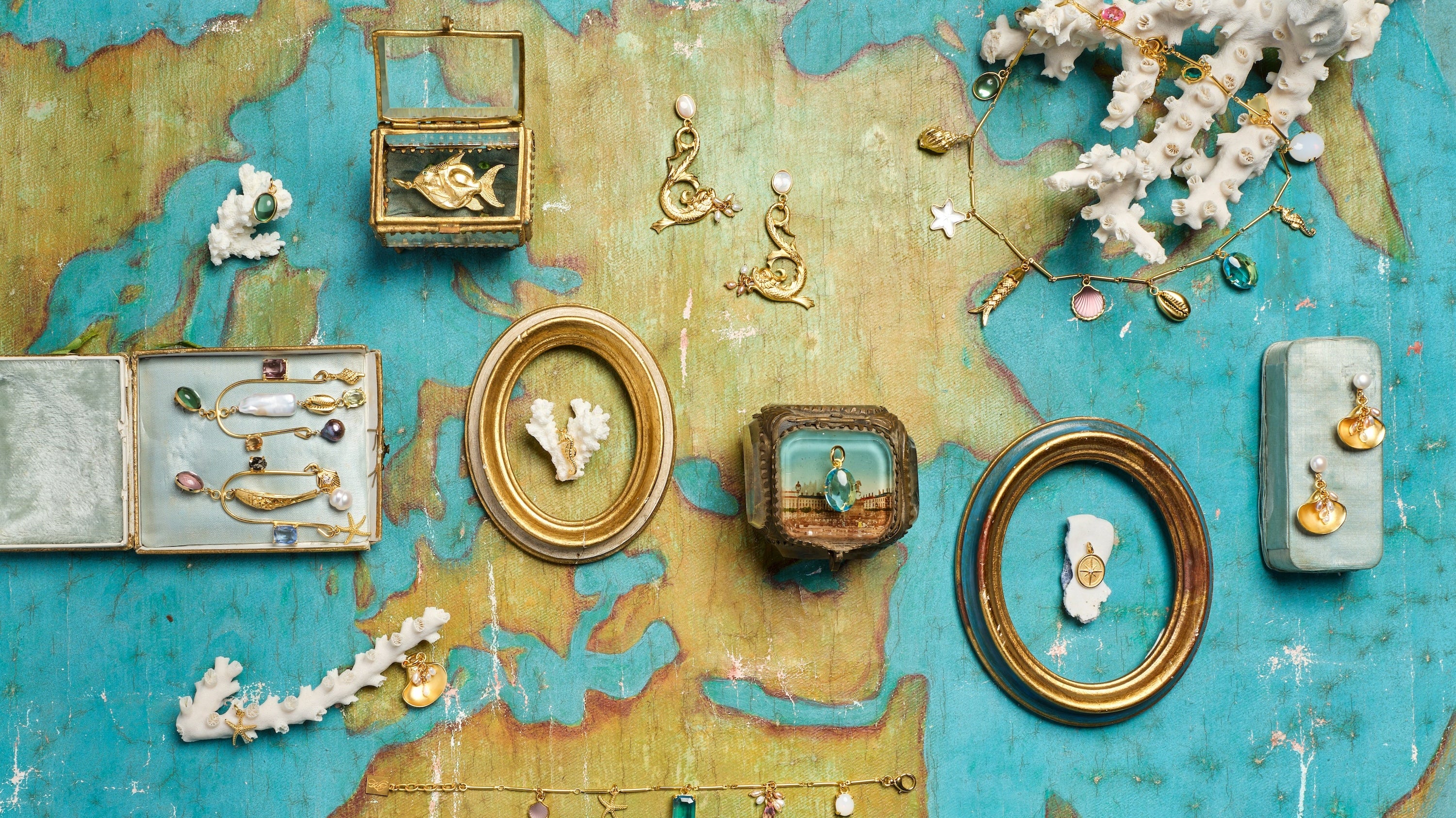 jewlery placed in boxes over an old world map