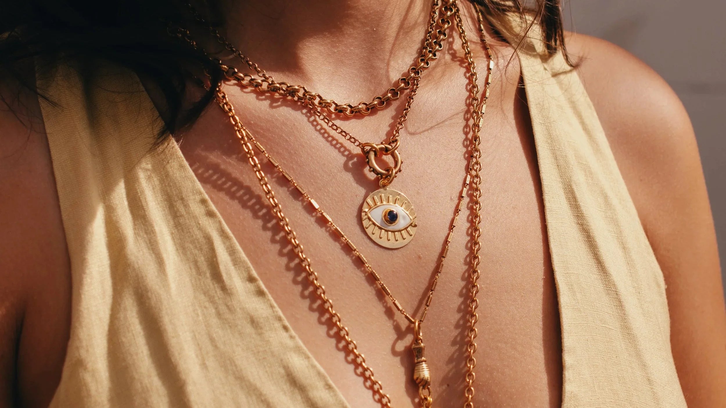 womans neck with layered jewelry pieces