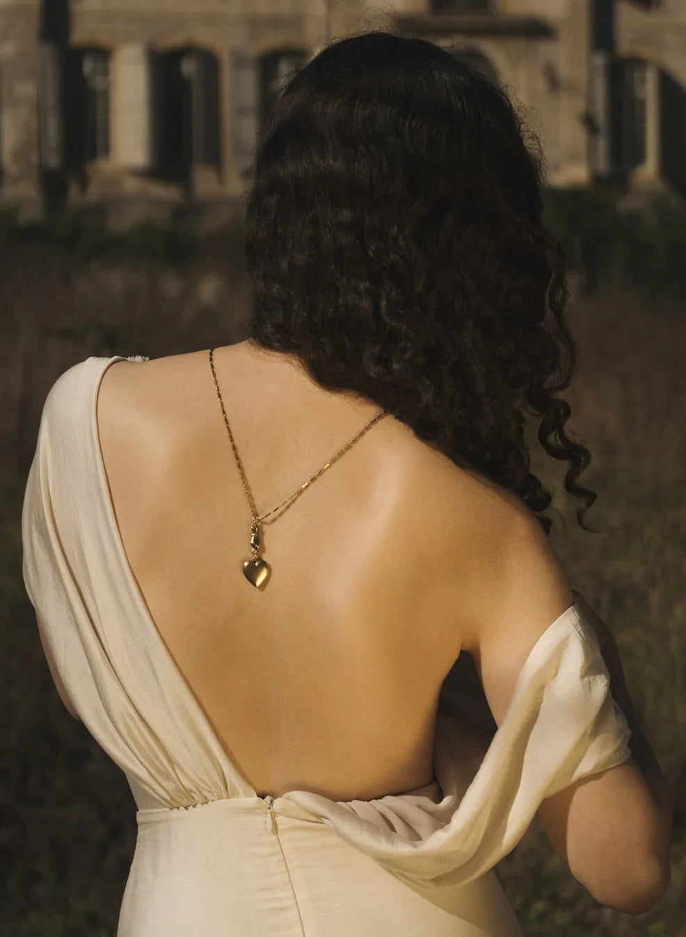 Womans back with a necklace draping down 